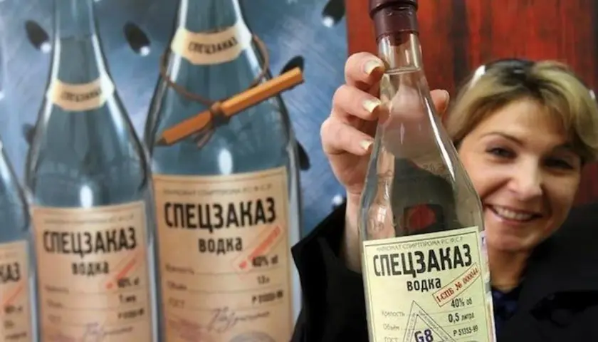Kobieta trzyma butelkę wódki "Speczakaz", która opowiada historię, skąd pochodzi wódka.
