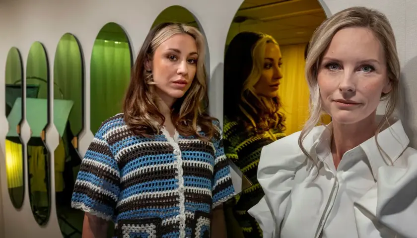 Två kvinnor poserar framför gröna speglar. Den ena bär en virkad tröja, den andra en vit skjorta. Kanske en scen från en emelie schepp serie?