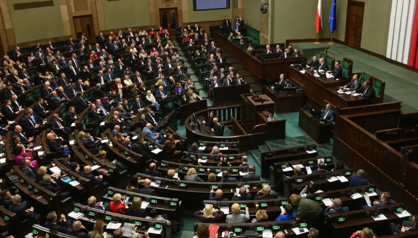 Posiedzenie Sejmu. Wiele osób siedzi w ławach, dyskutując o przyszłości kraju. Czy zaufanie do polityków jest uzasadnione?