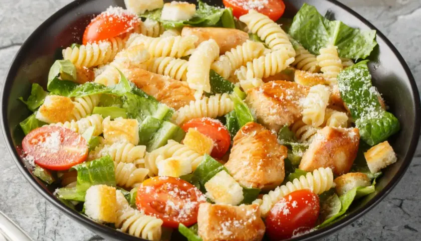 Prosta sałatka z piersią kurczaka, makaronem fusilli, pomidorkami koktajlowymi, grzankami i parmezanem.