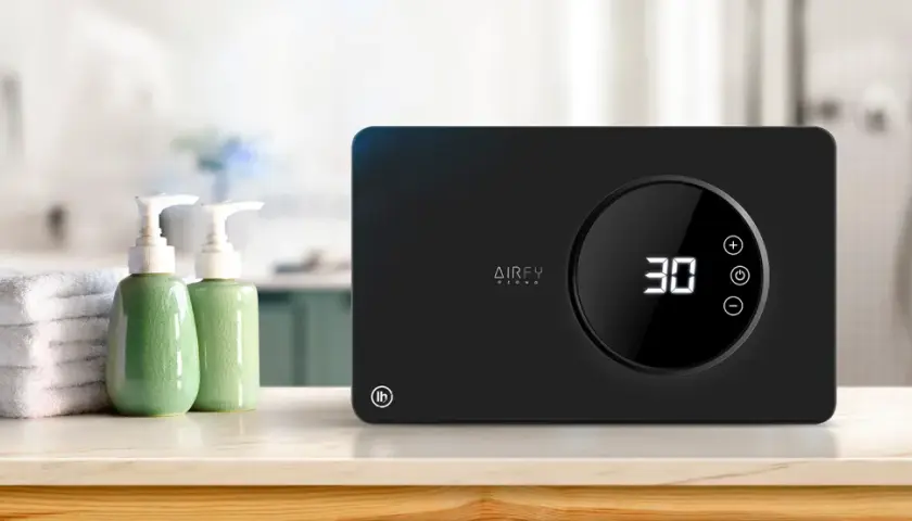 Purificador de aire AIRFY OZONO, con temporizador digital y controles táctiles. Junto a toallas y dispensadores de jabón, ideal para un ambiente fresco.