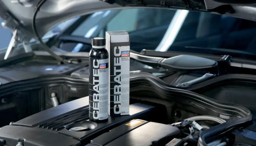 Botella y caja de LIQUI MOLY Cera Tec en un motor. Evita problemas de motor con este aditivo cerámico.