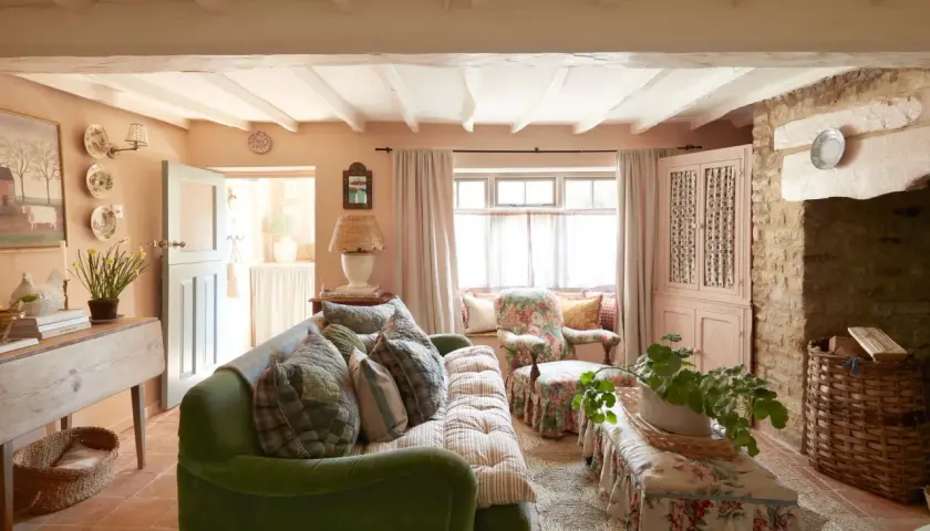 A cozy living room with a green sofa, floral armchair, and a bench, all embodying a charming modern grandma style.