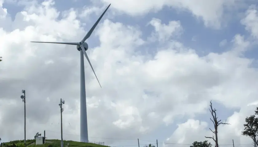 Wiatrak na wzgórzu symbolizuje rozwój energii odnawialnej w Polsce.