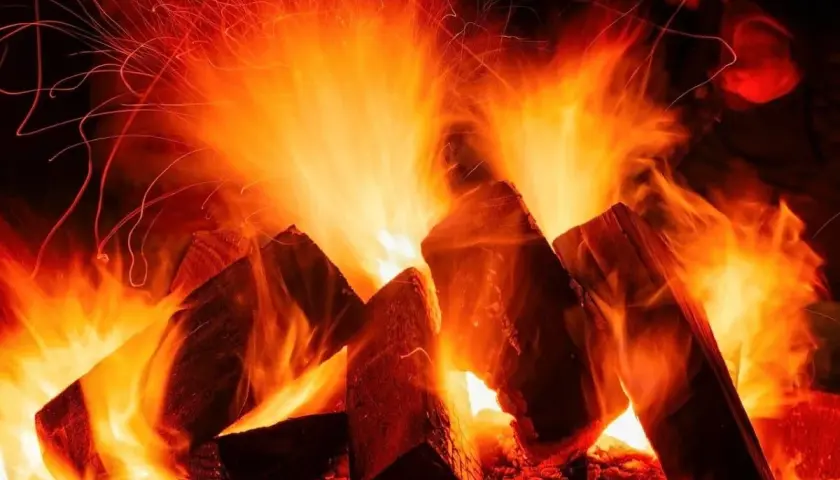 Flammen tanzen um Holzscheite, die zu einem knisternden Feuer werden. Ob buche hart oder weichholz, die Glut verspricht Wärme.