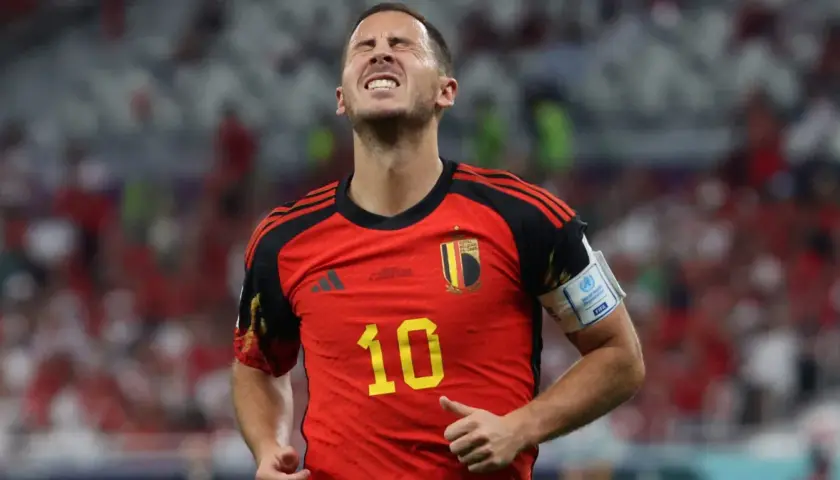 Hazard, belgijski piłkarz, z grymasem na twarzy, w czerwonej koszulce z numerem 10.