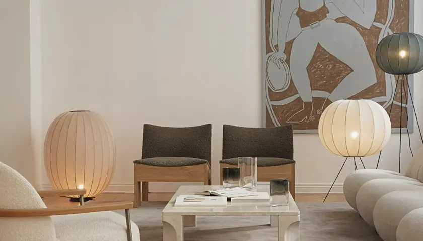 Sofá moderno y sillas junto a una mesa de centro con lámparas de pie y de mesa, todas con un diseño esférico y un casquillo G9 LED que ilumina suavemente el espacio.