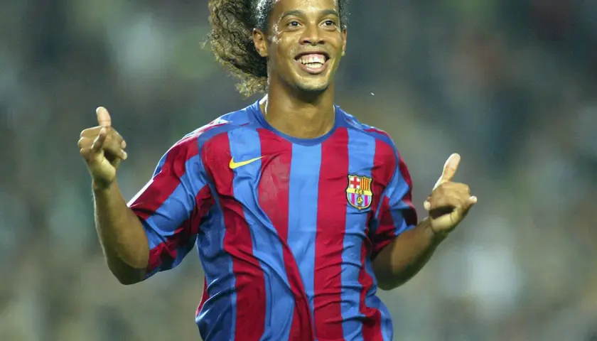 Ronaldinho w koszulce Barcelony, z charakterystycznym uśmiechem i uniesionymi kciukami, uosabia joga bonito.