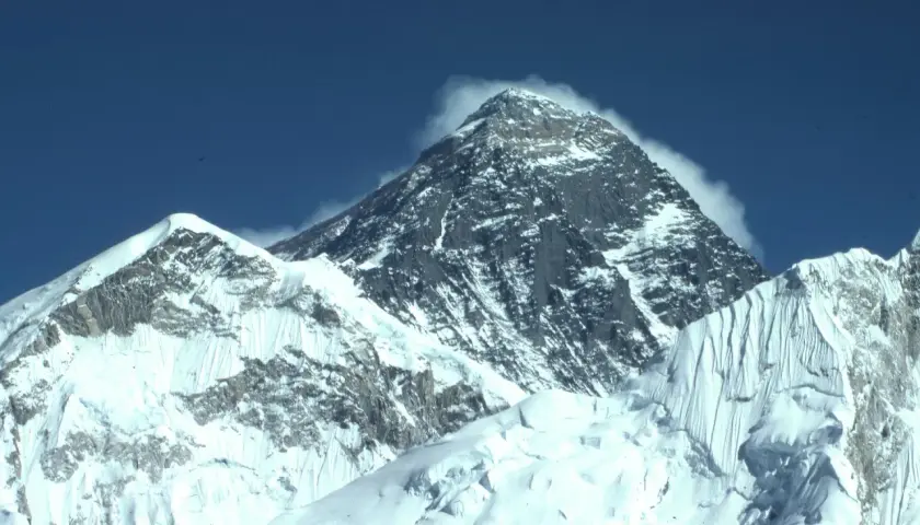 Majestatyczne szczyty pokryte śniegiem, chmury otulające wierzchołek. Widok zapierający dech w piersiach, symbol wejścia na Mount Everest.