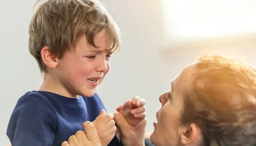 Un niño de 2 años llora desconsoladamente mientras su madre intenta calmarlo.