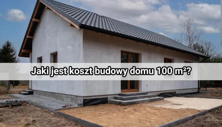 Budowa domu 100 m² – poznaj koszty. Nowy, szary dom w stanie surowym, z dachem i oknami, otoczony placem budowy.