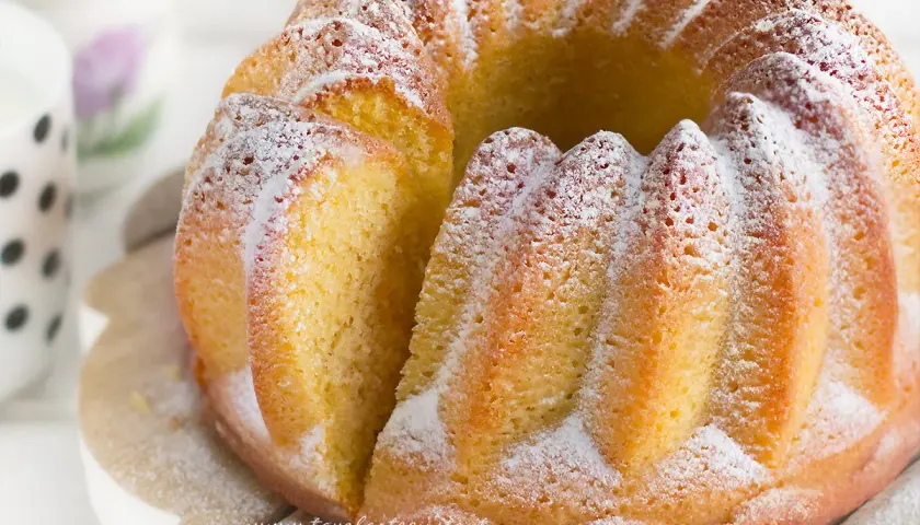 Un soffice ciambellone allo yogurt, spolverato di zucchero a velo, pronto per essere gustato.