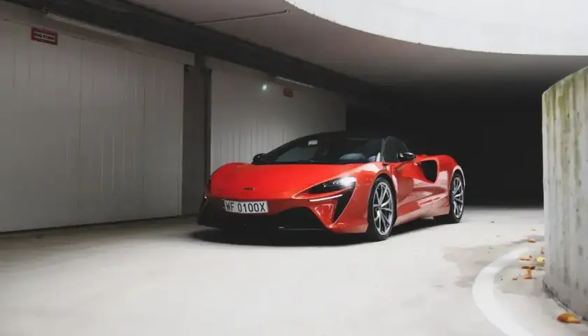 Czerwony McLaren w garażu, jego cena jest wysoka, ale wygląd zachwyca.