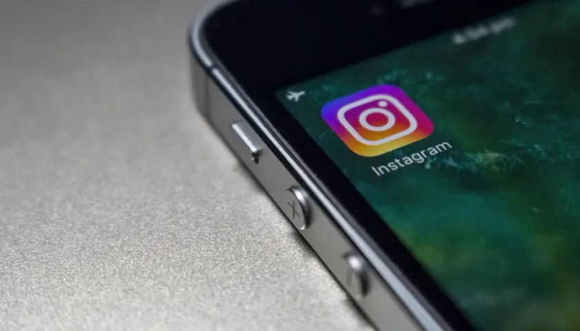 Zbliżenie na ekran telefonu z ikoną Instagrama. Czy widac screeny relacji na IG?