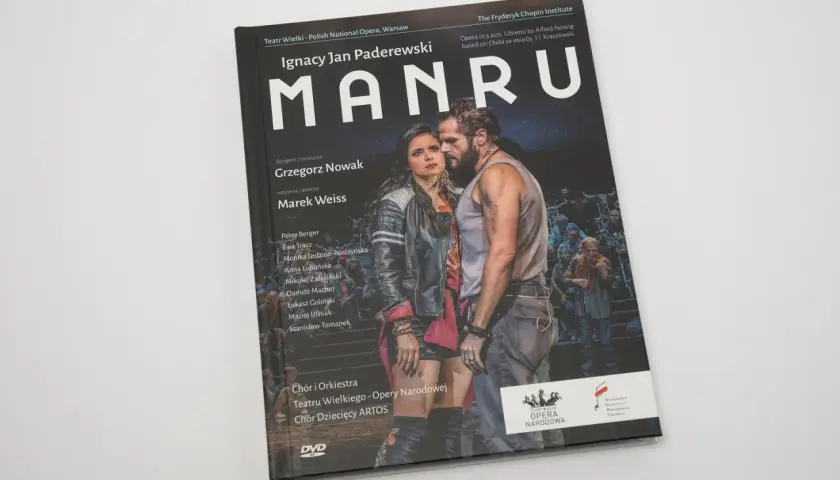 Okładka DVD z operą "Manru" Ignacego Jana Paderewskiego. Na pierwszym planie para aktorów, w tle tłum.