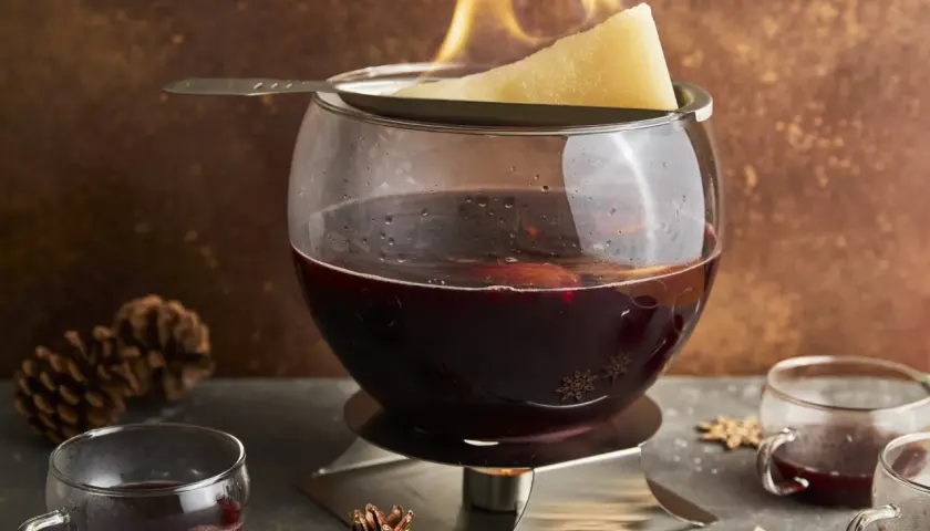 Alkoholfreie Feuerzangenbowle mit brennendem Zuckerhut und Gewürzen. Ein winterlicher Genuss für die ganze Familie.