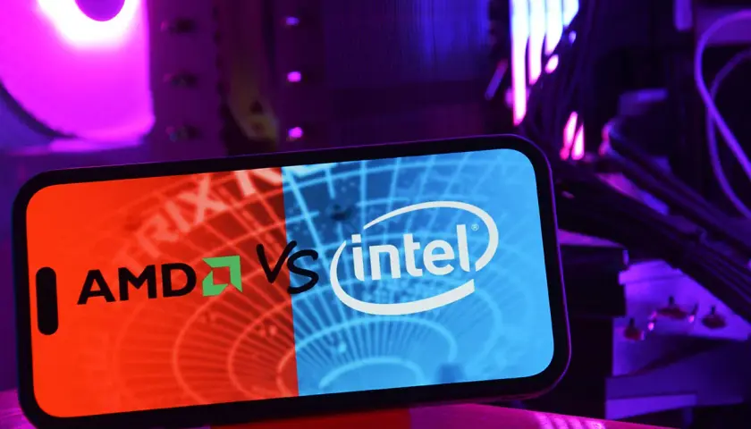 Telefon z logo AMD vs Intel na tle podświetlanego komputera. Wybór między procesorem Intel czy AMD.