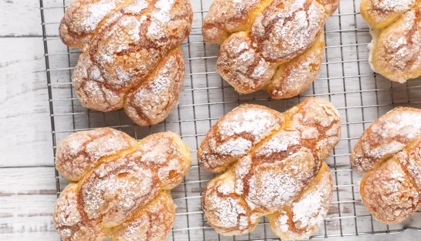 Colomba pasquale facile e veloce, dorata e cosparsa di zucchero a velo, raffreddata su una griglia.