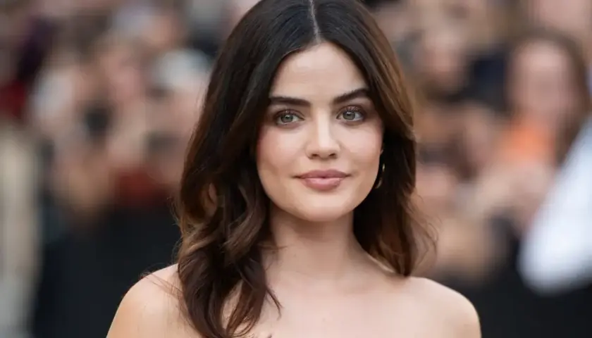 Mujer con media melena pelo liso y fino, ojos verdes y labios rosados, sonríe levemente.