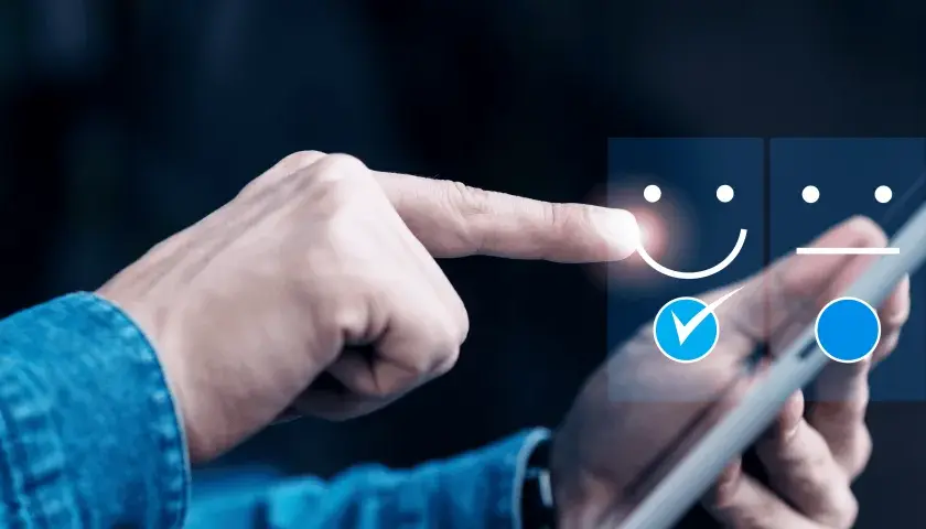 Dłoń wybiera uśmiechniętą buźkę na ekranie tabletu, oceniając jakość obsługi klienta (cx).