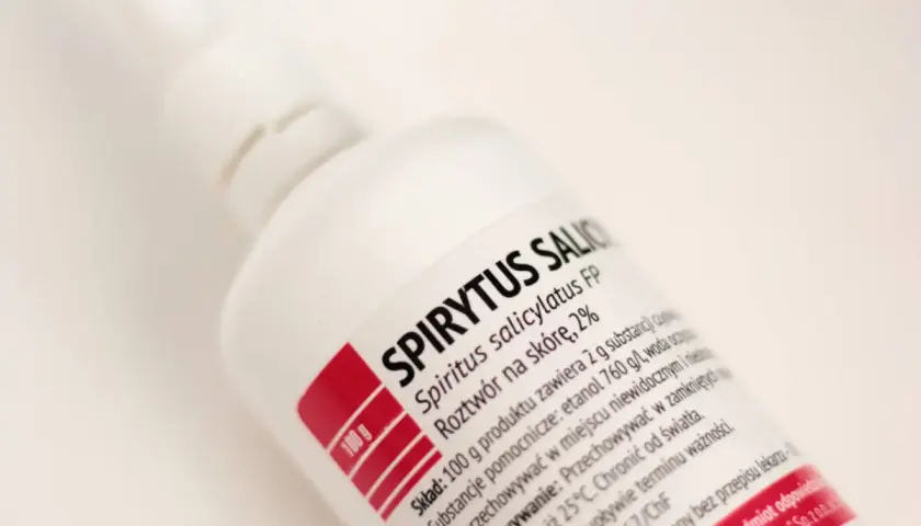 Biała butelka z etykietą "SPIRYTUS SALICYLATUS FP". Etykieta zawiera informacje o składzie, np. ile waży litr spirytusu.