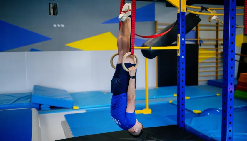 Ćwiczący na kółkach gimnastycznych, utrzymując pozycję odwróconą, pracuje nad siłą i wytrzymałością w swojej strefie tętna aerobowa.