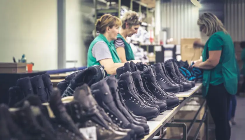 Workers inspect rows of Hanwag boots, hinting at where Hanwag boots are made: a factory floor.