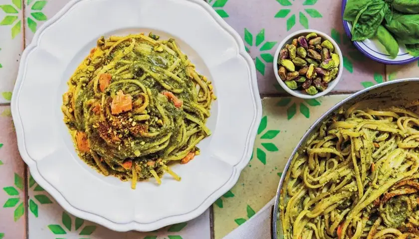 Linguine z pistacjami i zielonym pesto, idealne jaki makaron do pesto. Na talerzu i w garnku, z dodatkiem orzechów i bazylii.