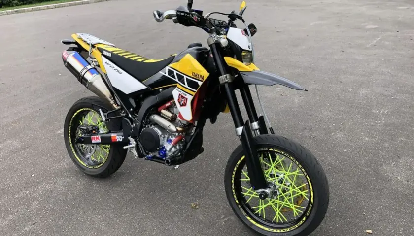 Yamaha WR 250 X personalizada con rines de radios amarillos brillantes y escape deportivo.