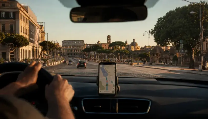 Navigatore in auto indica la strada per la stazione metro Anagnina, con il Colosseo sullo sfondo.