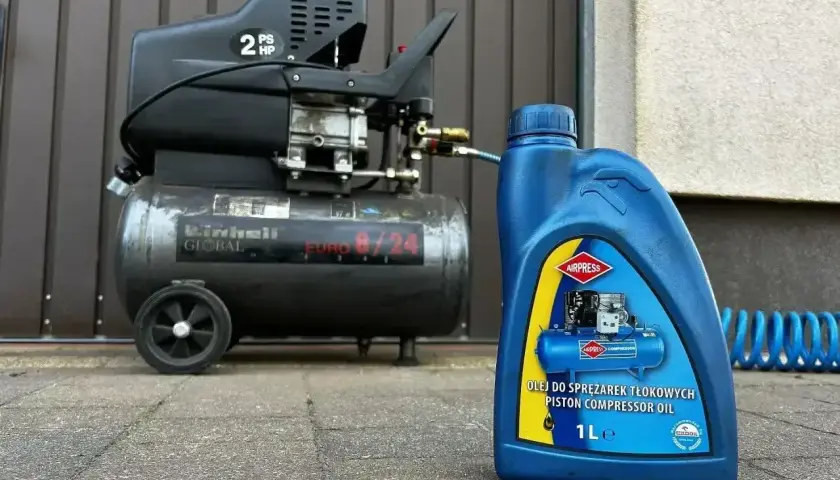 Butelka oleju do sprężarek tłokowych Airpress obok sprężarki Einhell. Pytanie: jaki olej do sprężarki?
