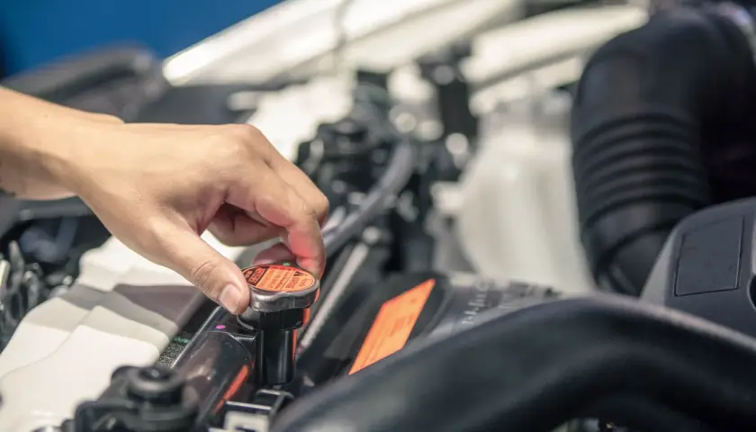 Dłoń odkręca korek chłodnicy samochodu Hyundai i30.