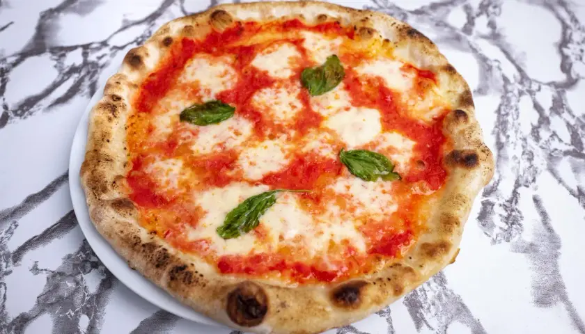Pyszna pizza neapolitańska z pomidorami, mozzarellą i bazylią. Zastanawiasz się, ile kalorii ma pizza neapolitanska?