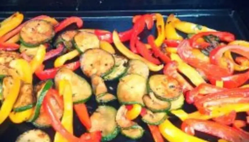 Légumes à la plancha marinés : poivrons rouges et jaunes coupés en lanières, courgettes rondes grillées. Un délice coloré !