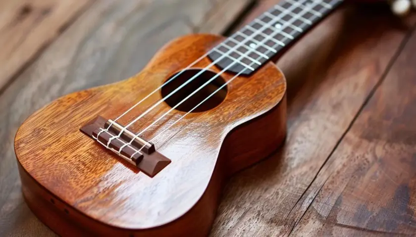 Drewniane ukulele dla dorosłych, gotowe do tworzenia melodii na rustykalnym tle.