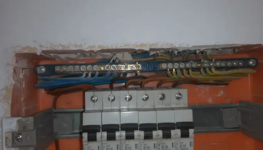 Instalacja elektryczna z listwą zaciskową. Jak sprawdzić uziemienie bez miernika? Widać przewody fazowe, neutralne i ochronne.