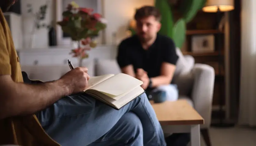 Un terapeuta ascolta e prende appunti, mostrando che il disturbo borderline si guarisce con il supporto giusto.