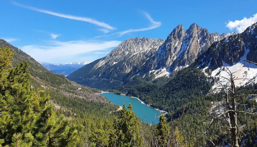 Lago turquesa rodeado de bosques y montañas nevadas, un paisaje espectacular cerca de Esterri d'Àneu.