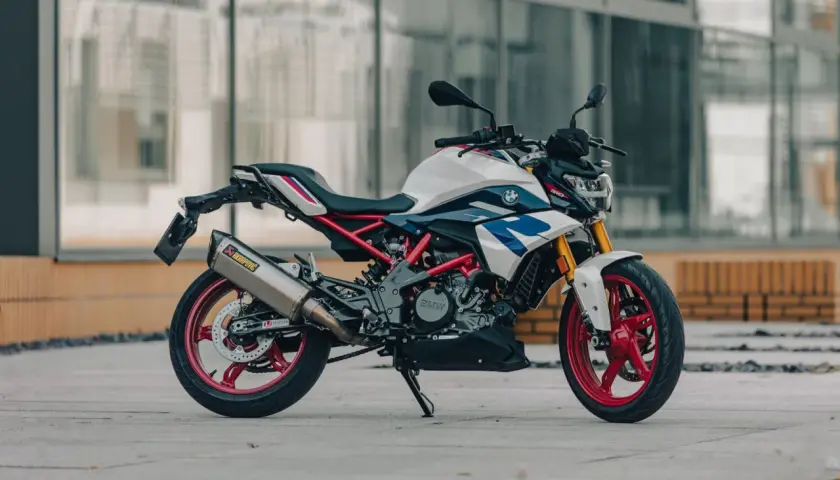 Biało-niebieski motocykl BMW G310R z czerwonymi felgami i wydechem Akrapovič. Poznaj jego bmw g310r dane techniczne.