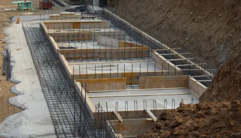 Przygotowanie do wylania ław fundamentowych. Widać zbrojenie i szalunki, które określą, ile betonu na ławy fundamentowe będzie potrzebne.
