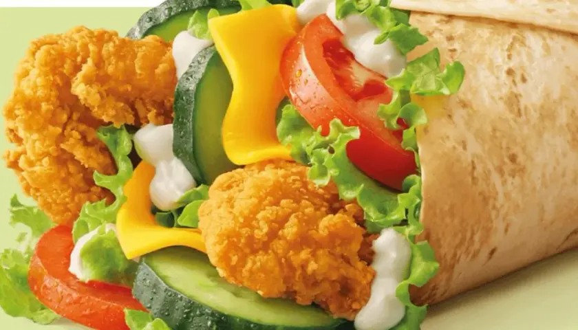 McWrap Bekon Deluxe: chrupiący kurczak, bekon, ser, warzywa i sos w tortilli. Pyszny i sycący, idealny na szybki posiłek.