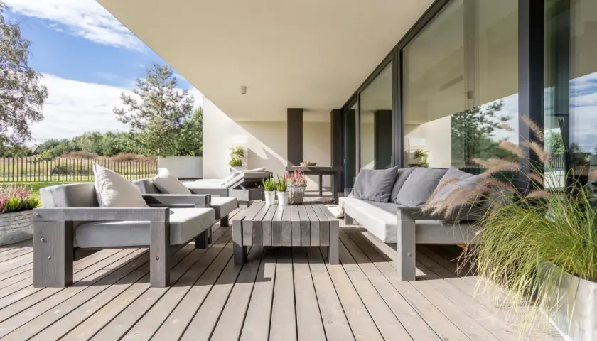 Moderne Lounge-Möbel auf Holzterrasse laden zum Entspannen ein. Perfekt, um die Terrasse gestalten und den Sommer zu genießen.