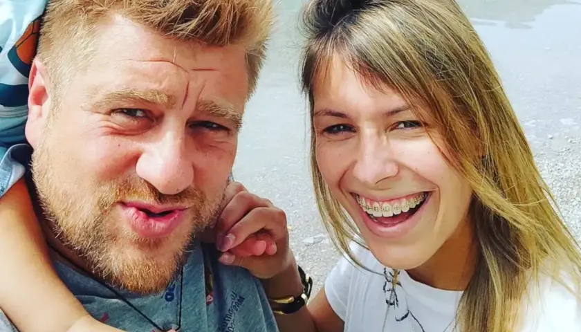 Tomasz Jakubiak z żoną i dzieckiem na wakacjach. Uśmiechnięta para cieszy się wspólnym czasem.
