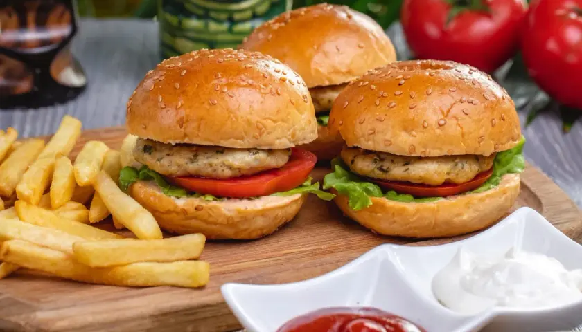 Pyszne burgery z indyka z chrupiącymi frytkami, pomidorami i sałatą. Idealne na szybki obiad.