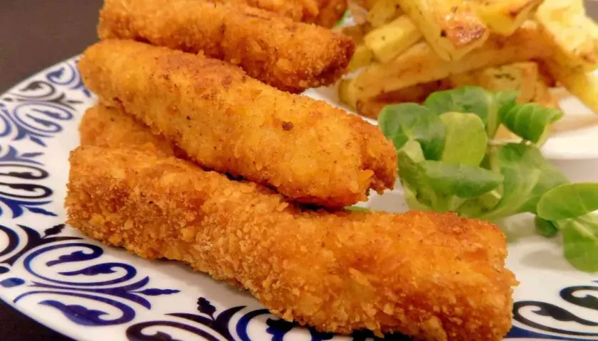 Chrupiące paluszki rybne lub kurczak w panierce, podane z frytkami i sałatką. Idealne na szybki obiad.