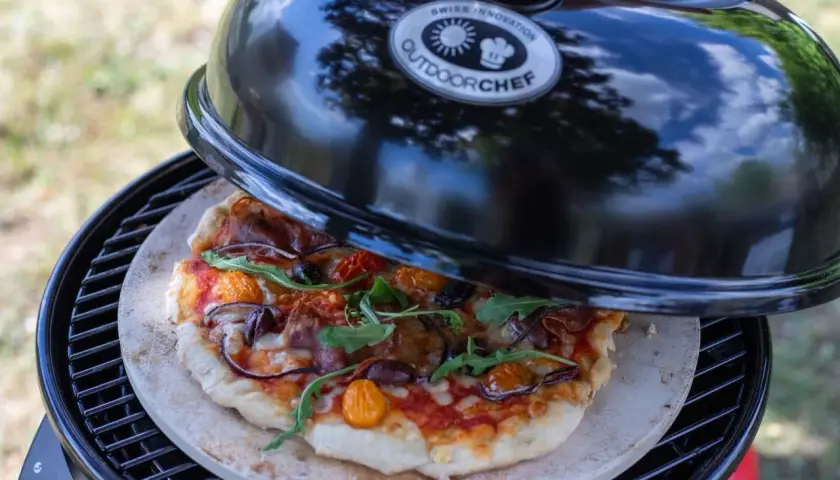 Selbstgemachte Pizza auf einem Pizzastein im Outdoorchef Grill. Die Frage ist nur, wieviel Grad im Ofen für den perfekten Biss?