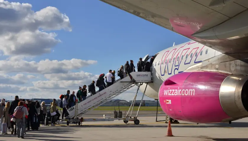 Pasażerowie wsiadają po schodkach do samolotu Wizz Air.
