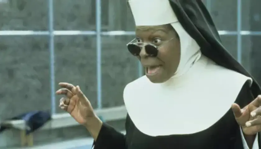 Whoopi Goldberg w roli siostry w filmie "Zakonnica w przebraniu 2: Powrót do habitu" z okularami i w rozbawionej pozie.