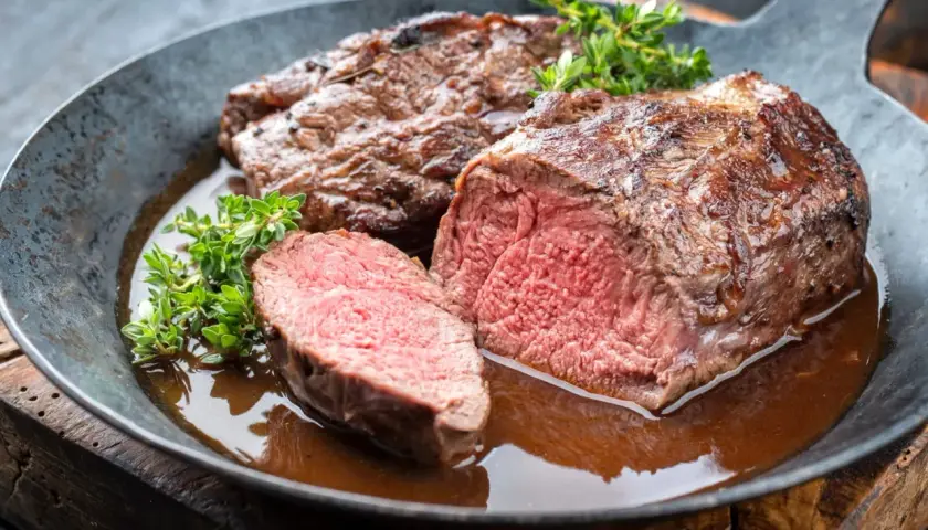 Un rôti de chevreuil juteux, coupé en tranches, baignant dans une sauce savoureuse. Un plat qui invite à se demander quel vin avec du chevreuil serait le meilleur accord.