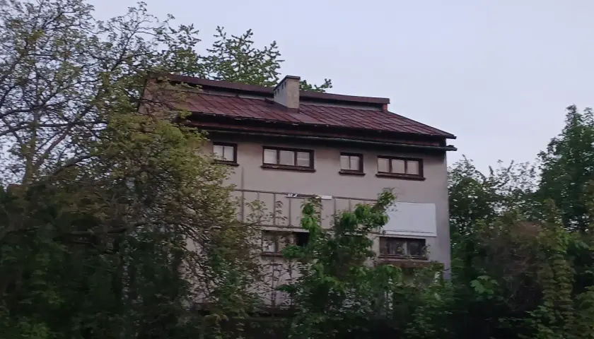 Stary, zaniedbany budynek otoczony drzewami, który według legend jest najbardziej nawiedzonym domem w Polsce.
